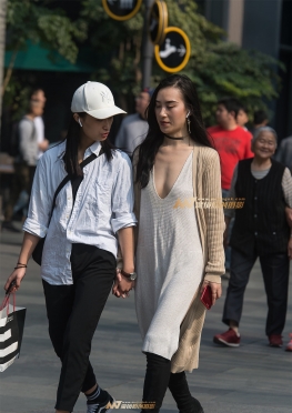 拉着手逛街的真空低胸美女